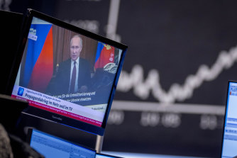 Russia’s President Vladimir Putin appears on a television screen at the stock market in Frankfurt, Germany on Friday.