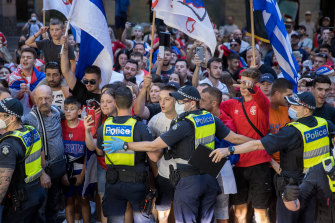 Police contain fans outside Djokovic’s lawyers’ offices in Melbourne on Monday night.