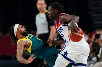 Patty Mills is bundled over by Jrue Holiday.