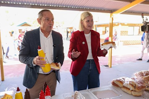 WA Premier Roger Cook and Georgia Tree the Labor Candidate have a sausage at Singleton Primary School polling booth.