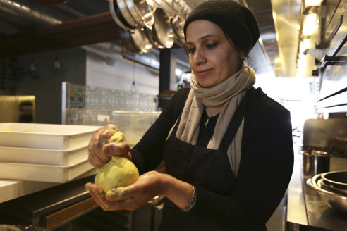Muna Anaee prepares a ball of khobz orouk, a flatbread from her native Iraq, at the Tawla restaurant kitchen in San Francisco.