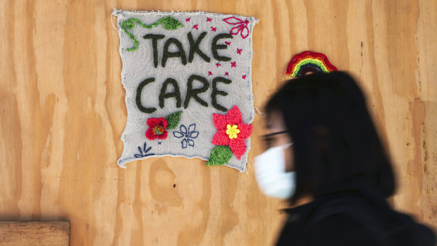 A pedestrian walks past a "yarnbomb" made by artist Ellie d'Eustachio during the coronavirus pandemic, in Brooklyn, New York.