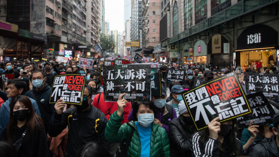 Demonstrators hold signs during a protest in the Causeway Bay district of Hong Kong.