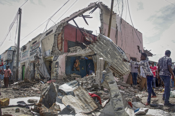 Somalis clear wreckage at the scene, after gunmen stormed a hotel in the capital Mogadishu.