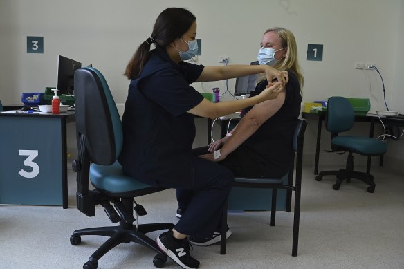 Nurse immuniser Zoe Leung (left) administering a COVID-19 vaccine to Fiona Paine.