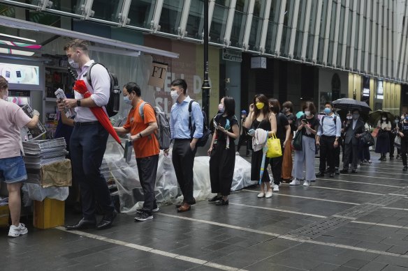 Customers queue up for last issue of Apple Daily at a newspaper booth at a downtown street in Hong Kong on Thursday. 