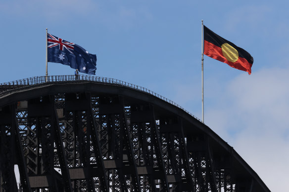 The Australian and Aboriginal flags fly side-by-side on the Harbour Bridge on Australia Day this year.