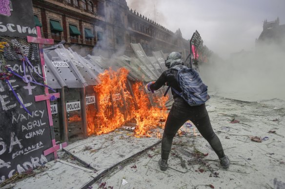 A demonstrator throws burning petrol at a police shield wall during a march to commemorate International Women’s Day in Mexico City on Monday, March 8.