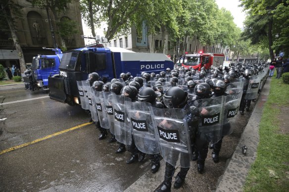 Riot police block a street to prevent demonstrators during an opposition protest against “the Russian law” near the Parliament building in the centre of Tbilisi, Georgia.