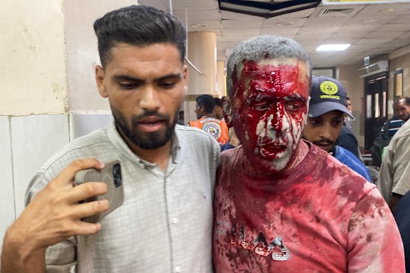 Injured Palestinian photojournalist Hatem Omar is helped after the attack.