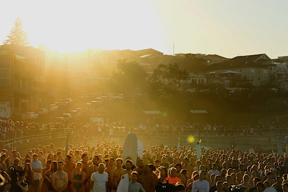 Hundreds of people listen to speeches before the paddle-out on December 19.