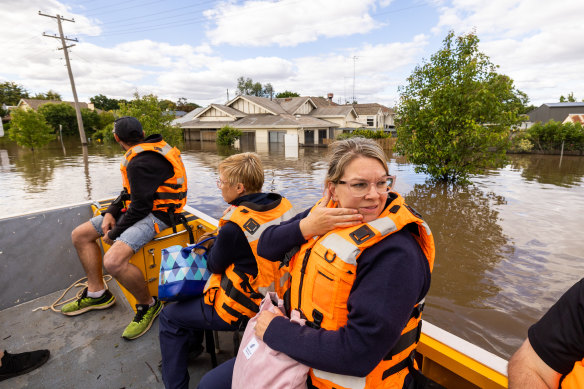 Bailee Harrison, nurse unit manager at Forbes District Hospital, is transported by boat across flooded streets in Forbes at the end of her shift with a crew from Maritime NSW.