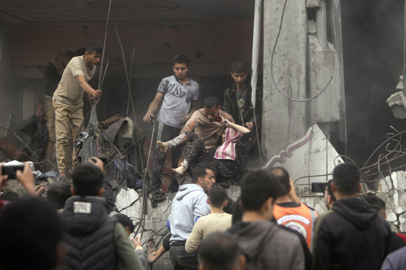 Palestinians rescue a woman from a destroyed building following Israeli airstrikes in Khan Younis refugee camp, southern Gaza Strip.