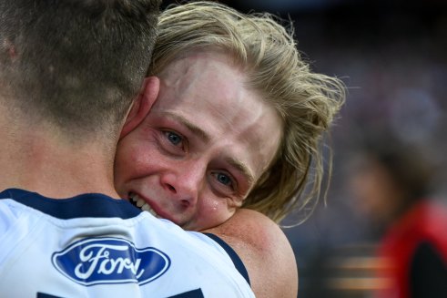 An emotional Zach Guthrie is embraced by Joel Selwood.