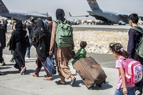 Evacuees walk towards their flight at Kabul airport.