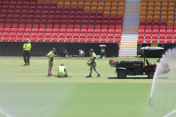 Groundsmen work to repair the Suncorp Stadium pitch after two country music concerts.