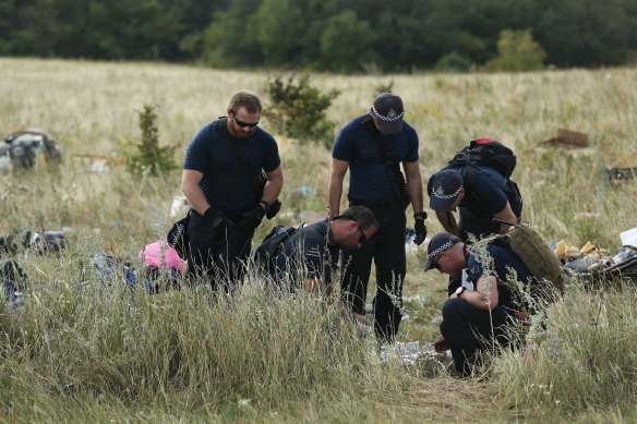 Australian Federal Police officers and their Dutch counterparts collect human remains from the MH17 crash site.