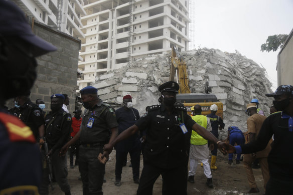 Rescue workers are seen at the site of a collapsed 21-storey apartment building under construction in Lagos, Nigeria, on Tuesday AEDT.