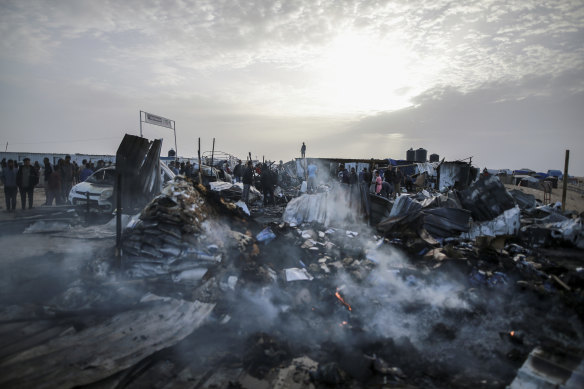 Palestinians look at the destruction after an Israeli strike where displaced people were staying in Rafah.