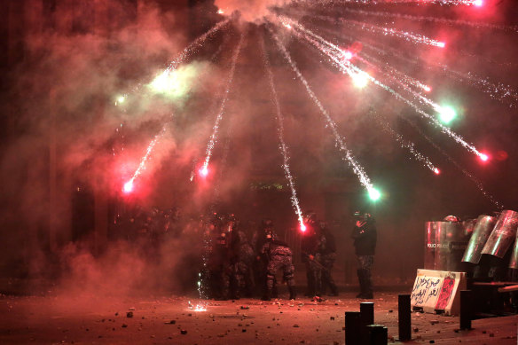 Protesters shoot fireworks towards riot police on a road that lead's to Lebanon's Parliament.