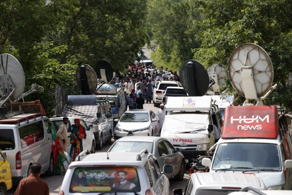 Media vans and supporters of Pakistan’s former Prime Minister Imran Khan’s party gather outside his residence in Islamabad on Monday.
