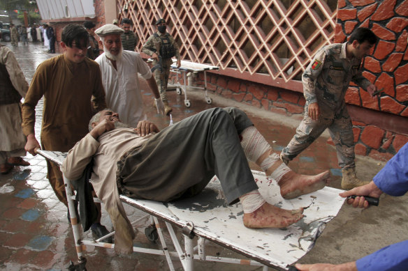 A wounded man is brought by stretcher into a hospital after a bombing at a mosque during Friday prayers.