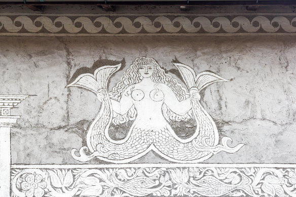 Traditional Sgraffito house facade with a mermaid figure.