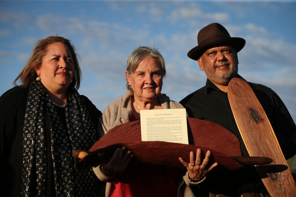Indigenous advocates Megan Davis, Pat Anderson and Noel Pearson with a piti holding the Uluru Statement from the Heart, which called for a Voice to parliament.
