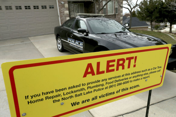The warning sign and a police officer's vehicle at the victim's home in North Salt Lake, Utah., after plumbers, prostitutes and others were sent to the address. 