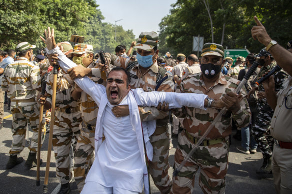 A man is detained by soldiers in New Delhi during widespread protests across India.