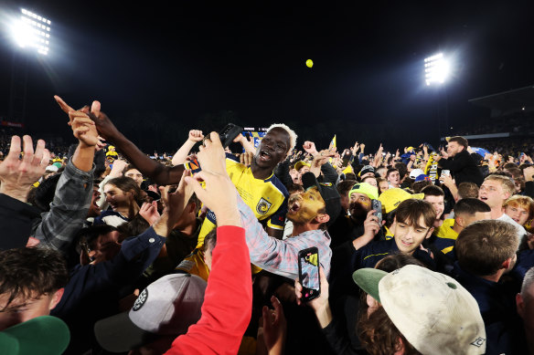 Alou Kuol of the Central Coast Mariners celebrates winning with fans.