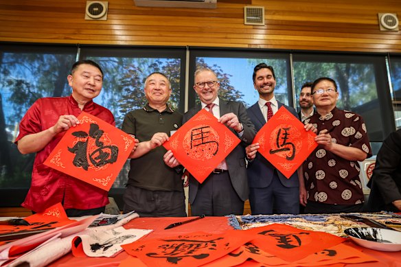 Anthony Albanese, with the MP for Menzies Gabriel Ng (second from right), displays his calligraphy piece.