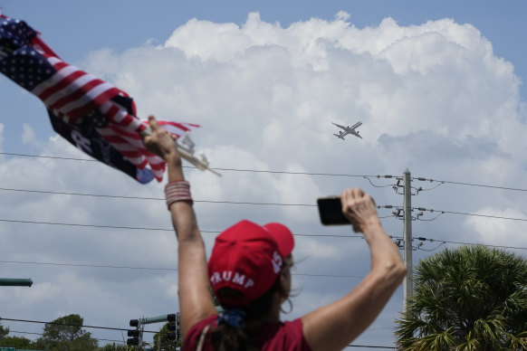 Donald Trump'ın bir destekçisi, uçağı Palm Beach Uluslararası Havaalanı'ndan kalkarken el sallıyor.