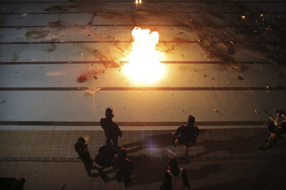 Protesters practice throwing molotov cocktails into a swimming pool at Hong Kong Polytechnic University.