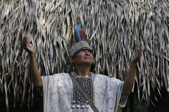 Shaman Pablo Flores raises his hands to the sky before the beginning of an ayahuasca session, in Nuevo Egipto, a remote town in the jungles of Peru. 