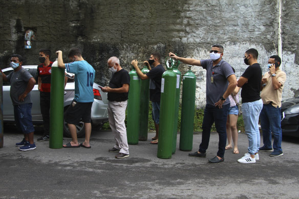 Family members of patients hospitalised with COVID-19 line up with empty oxygen tanks in an attempt to refill them, in Manaus, Amazonas state, Brazil.