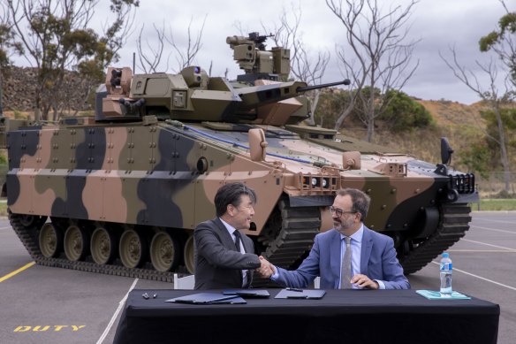 Trade Minister Martin Pakula and Hanwha Australia managing director Richard Cho in front of Hanwha's Redback vehicle on Tuesday.