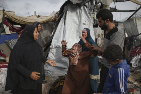 Displaced Palestinians inspect their tents destroyed by Israeli strikes at a UN facility west of Rafah.
