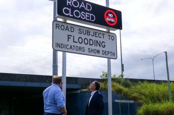 The first automatic flood warning signs for Brisbane streets are inspected by lord mayor Adrian Schrinner (right) and infrastructure committee chair Andrew Wines.