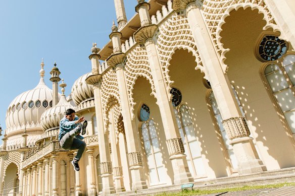 A visitor leaps outside the former royal residence, built in 1787 as a seaside retreat for George, Prince Regent.