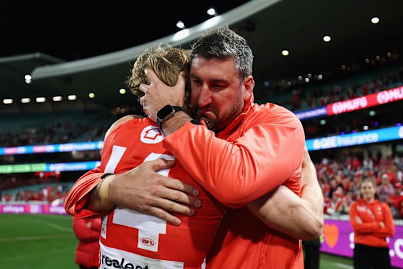 Callum Mills of the Swans embraces Swans head coach Dean Cox. 