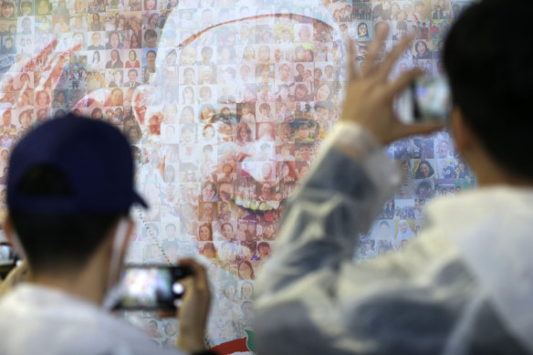 People observe a wall painting depicting Pope Francis at Nagasaki Prefectural Baseball Stadium.