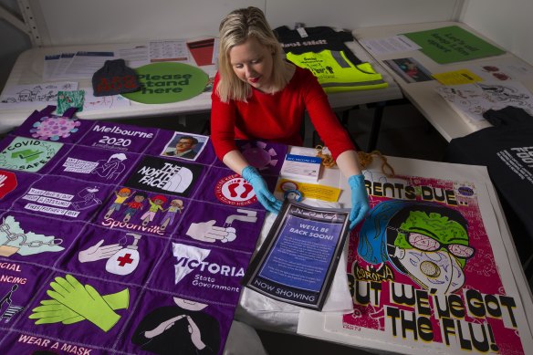Michelle Stevenson from Museums Victoria with the cinema closure sign, a handmade quilt and other COVID-19 pandemic related items.
