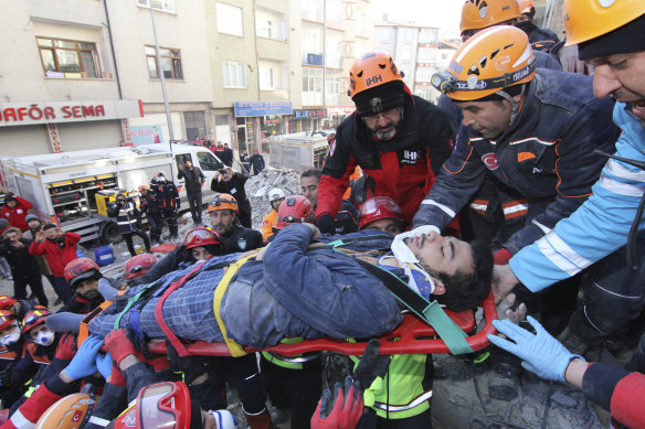 Rescue workers on Saturday carry a wounded man who was found alive in the rubble of a building destroyed by Friday's earthquake in Elazig, eastern Turkey.