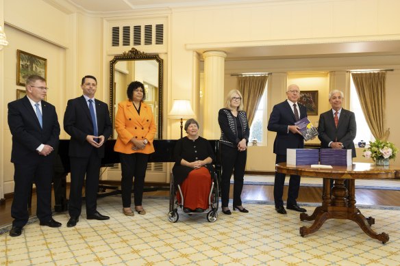 Disability royal commission chair Ronald Sackville (right) and commissioners (l-r) John Ryan, Alastair McEwin, Andrea Mason, Dr Rhonda Galbally, Barbara Bennett hand their final report to Governor-General David Hurley (second from right) on Thursday.