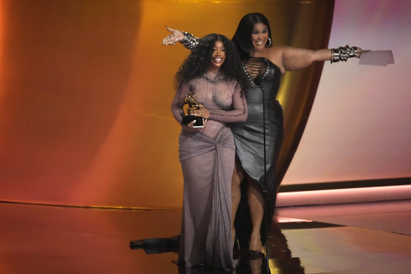 Lizzo (right) presents the award.