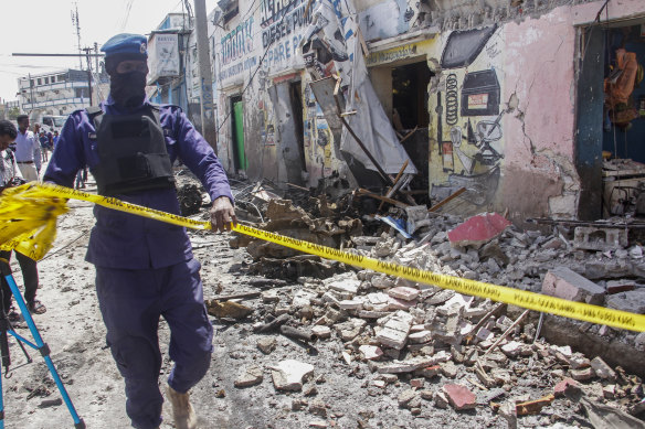 A member of security forces cordons off wreckage at the scene.