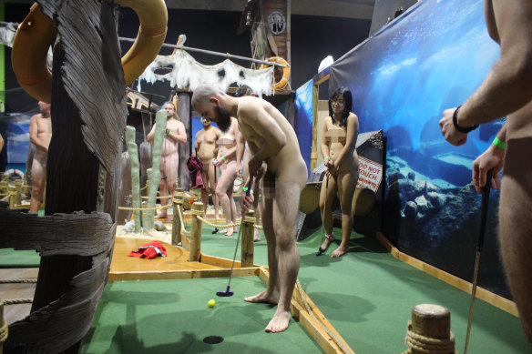 The nude mini-golf event organised by the Young Nudists of Australia. A green wristband means the person has consented to photographs. Photo has been digitally censored.