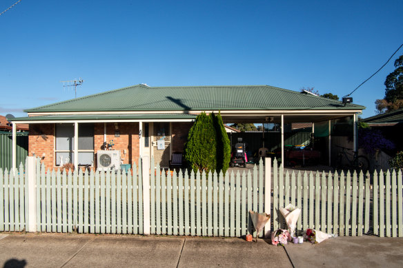 Flowers outside Emma Bates home on Thursday. A mobility scooter can be seen underneath her porch.