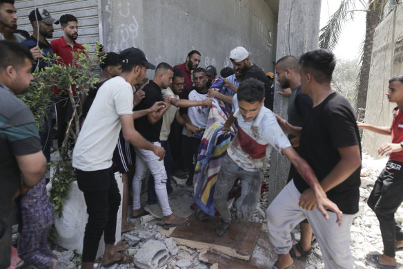 Palestinians evacuate dead and wounded after an Israeli bombardment of Deir al-Balah in the Gaza Strip on Saturday.